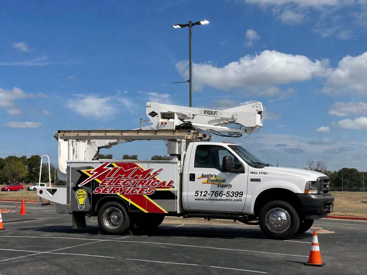 Simms Electrical Services bucket truck beneath a parking lot light pole in Austin, TX
